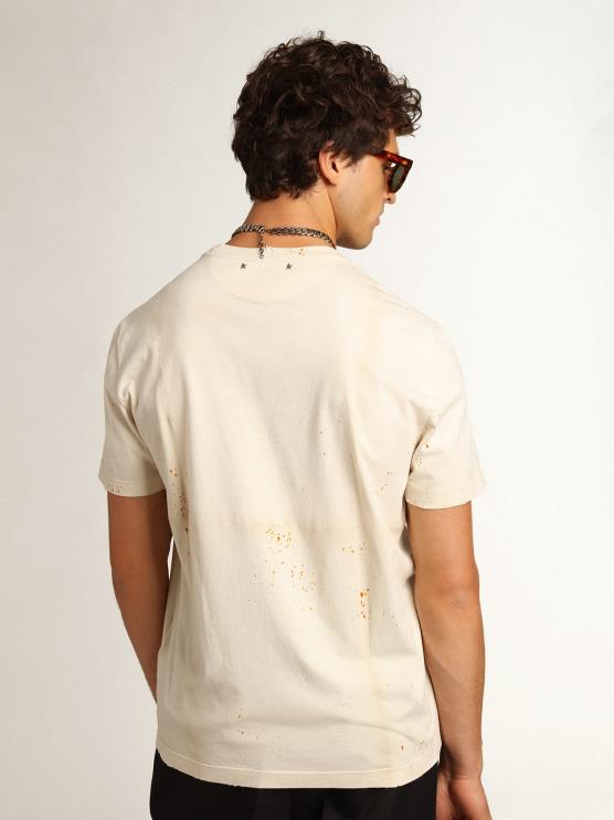 FDVPX728hombres camiseta de la colección travel en blanco hueso con efecto de prenda doblada con letras doradas y spray color óxido